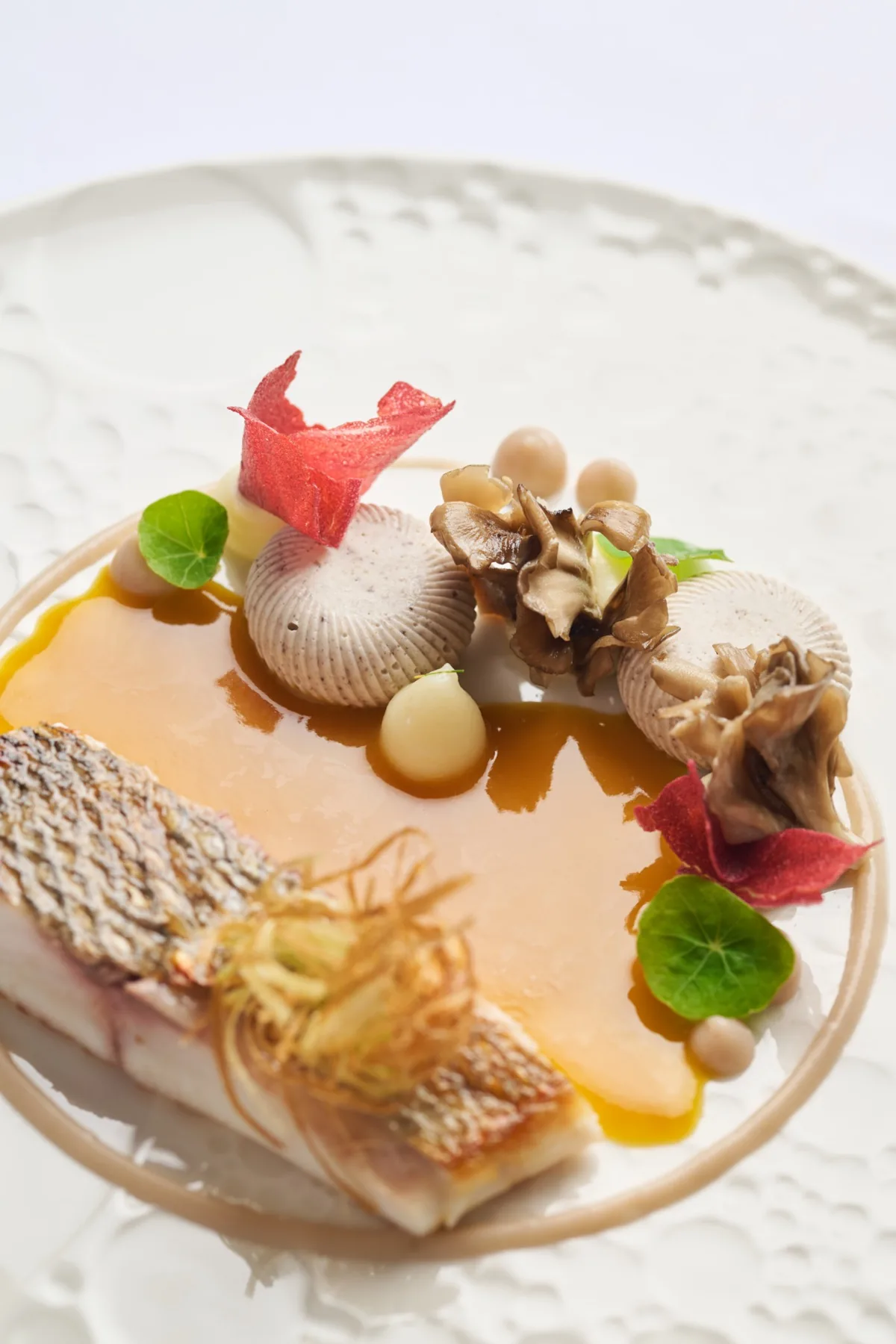 Assiette gastronomique avec poisson et garnitures dressée par le chef privé