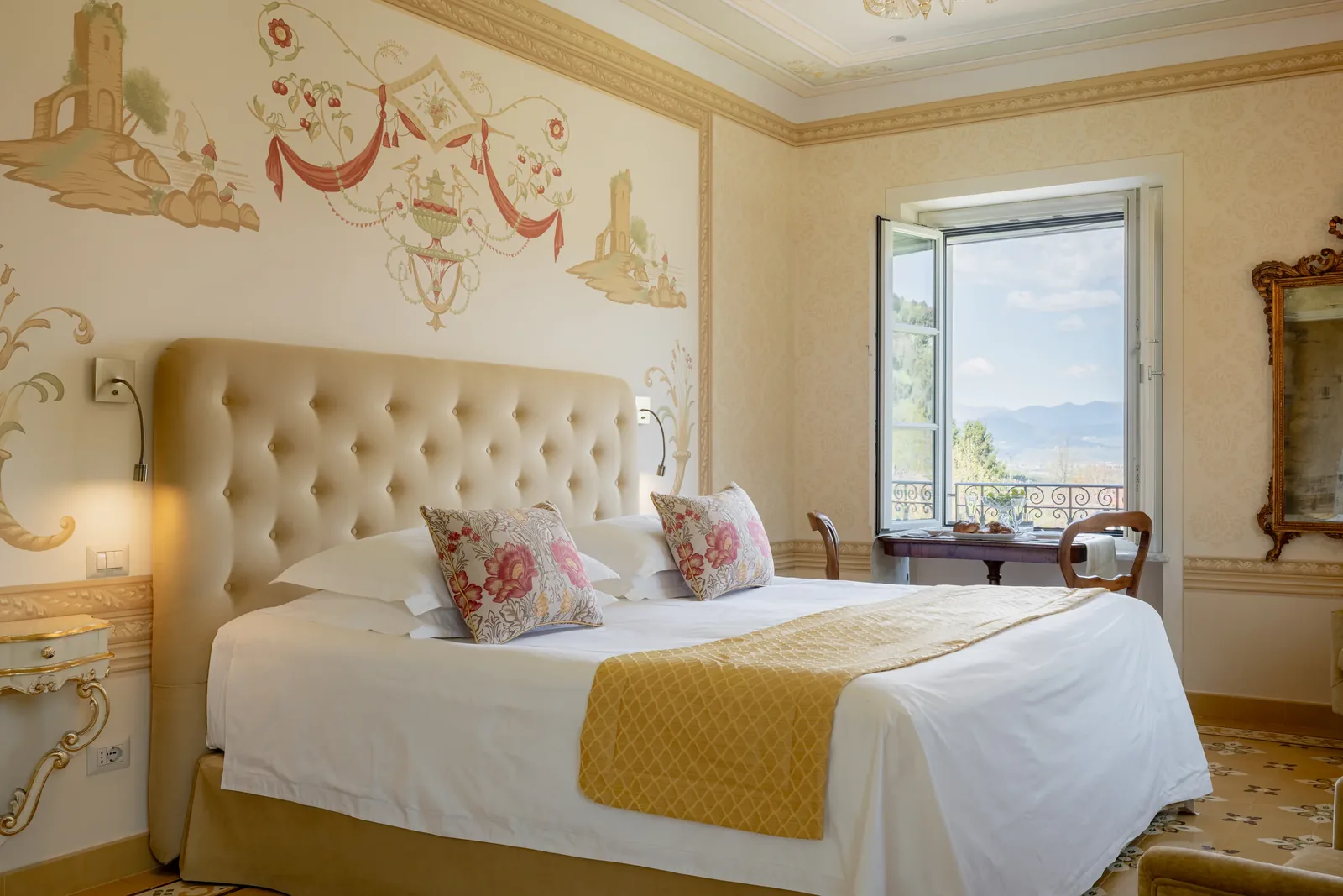 Chambre jaune de Villa Marie avec tête de lit capitonnée et décor mural peint