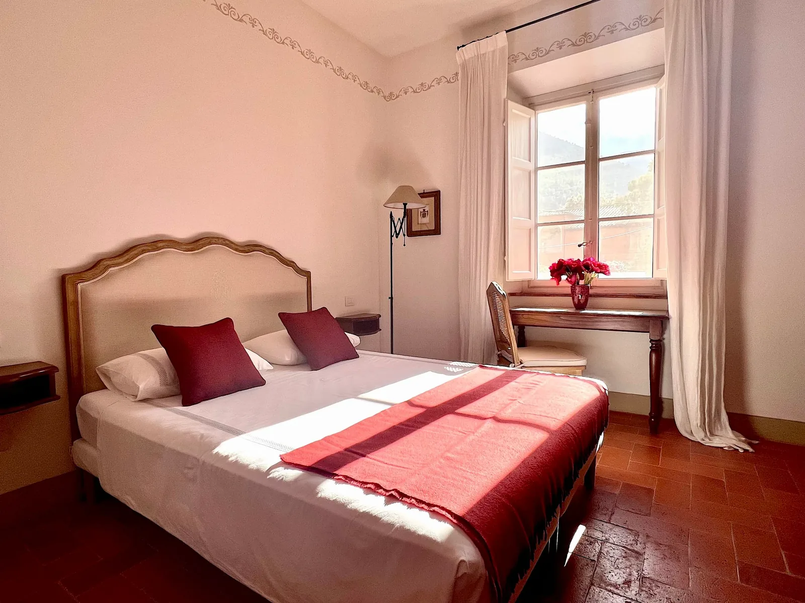Chambre rose de Casa del Contadino avec lit double et couvre-lit rouge