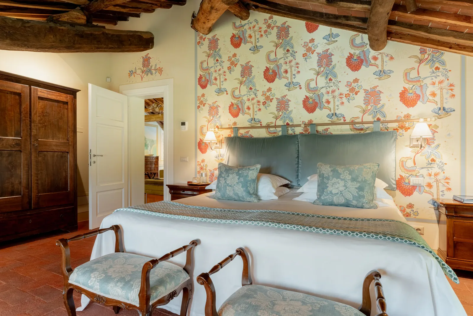 Chambre turquoise de Villa Marie avec lit double, décor floral et poutres apparentes