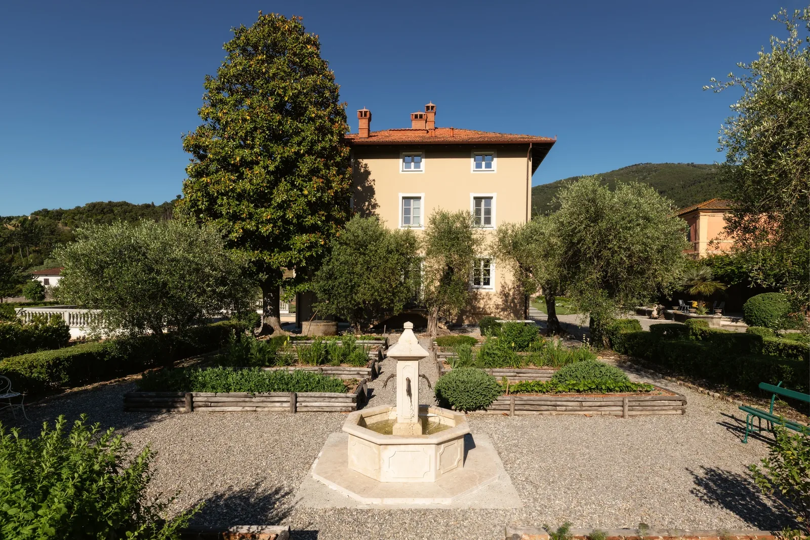 Fontaine devant la façade de Villa Marie et les parterres du jardin