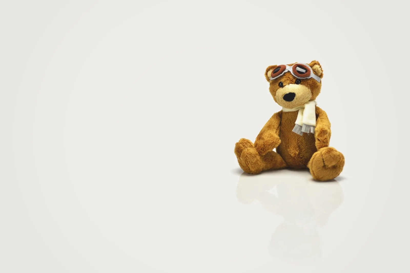 Ours en peluche avec lunettes d’aviateur sur fond clair