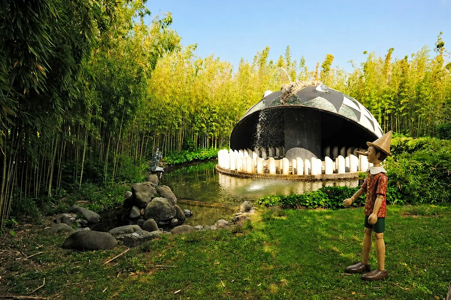 Pinocchio à côté de la sculpture de la baleine dans le parc de Pinocchio à Collodi