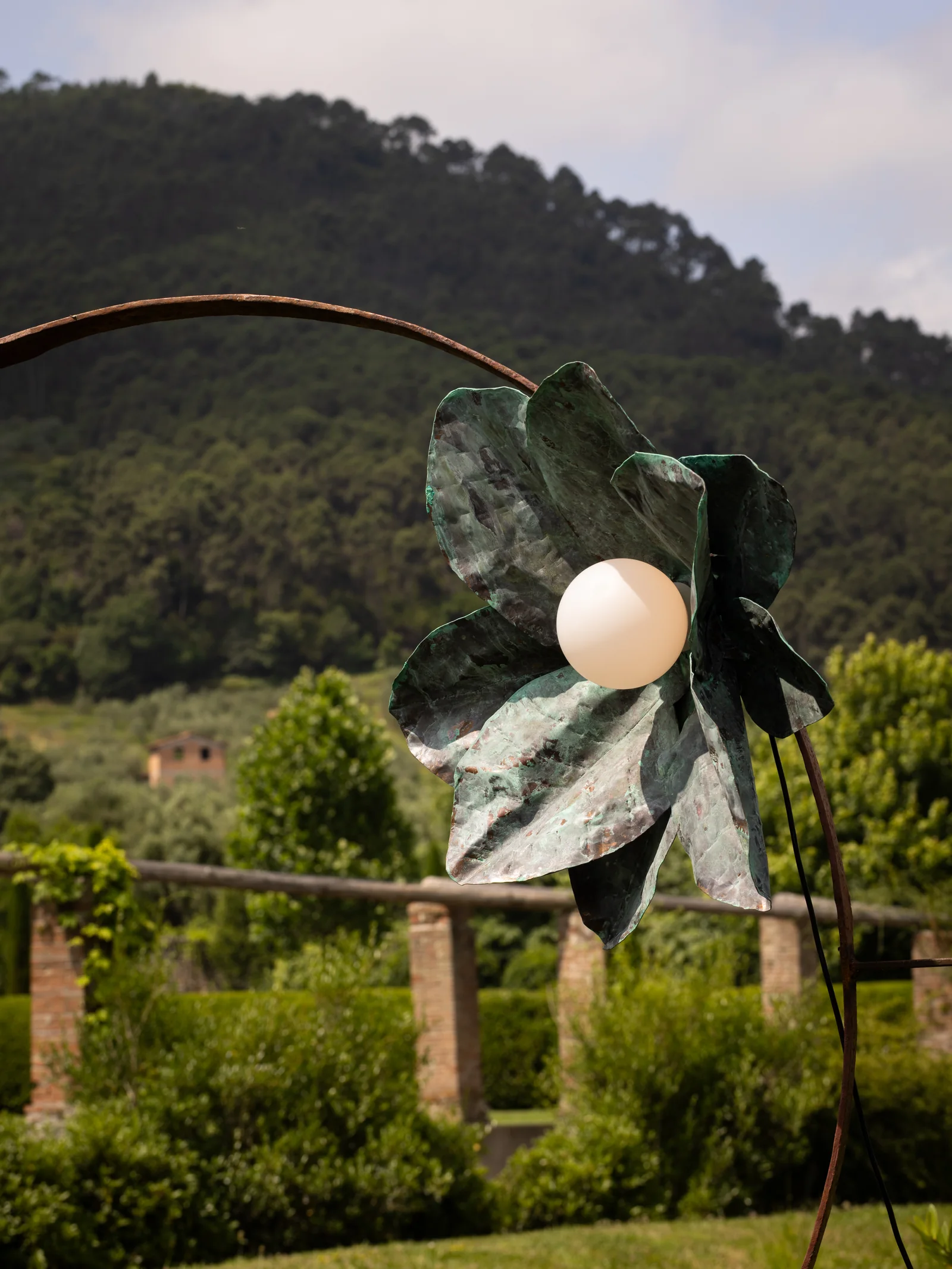Sculpture de fleur en métal face aux collines toscanes à Villa Marie