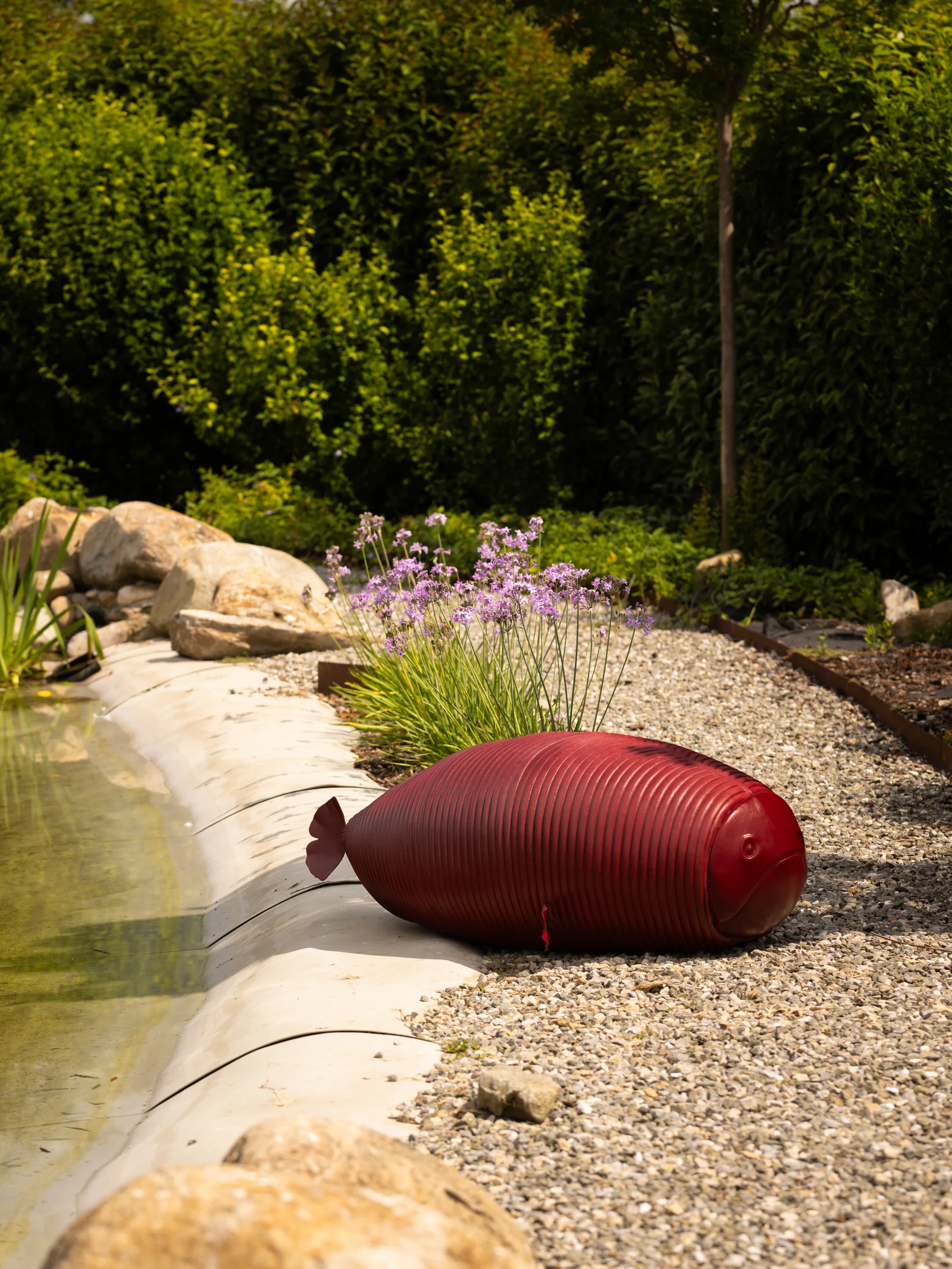 Sculpture de poisson rouge près du bassin du jardin de Villa Marie