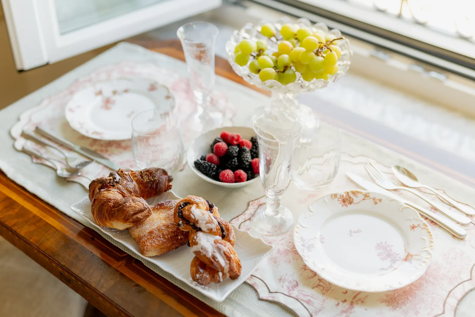 Table du petit-déjeuner avec croissants et fruits à Villa Marie