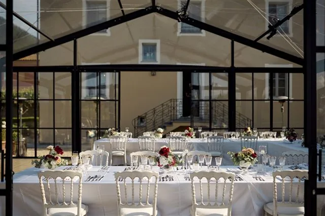 Tables dressées pour une réception sous une verrière