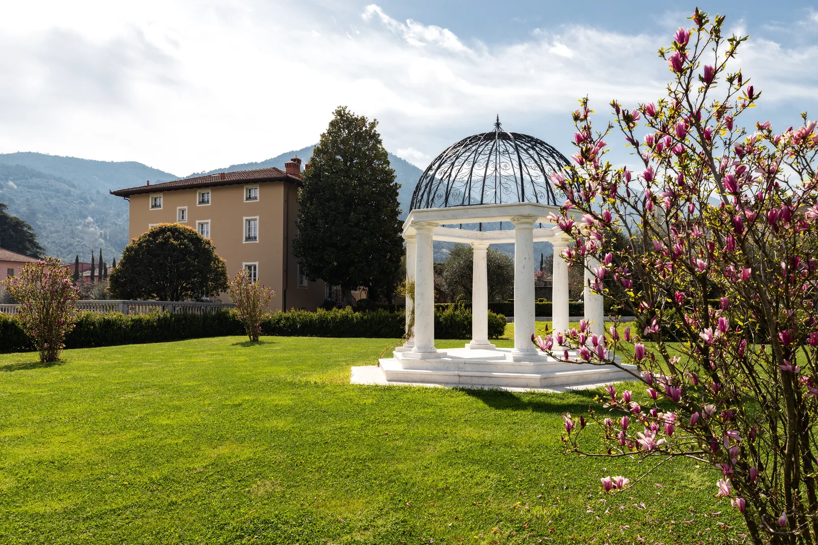 Chiosco di marmo bianco e albero fiorito nei giardini di Villa Marie