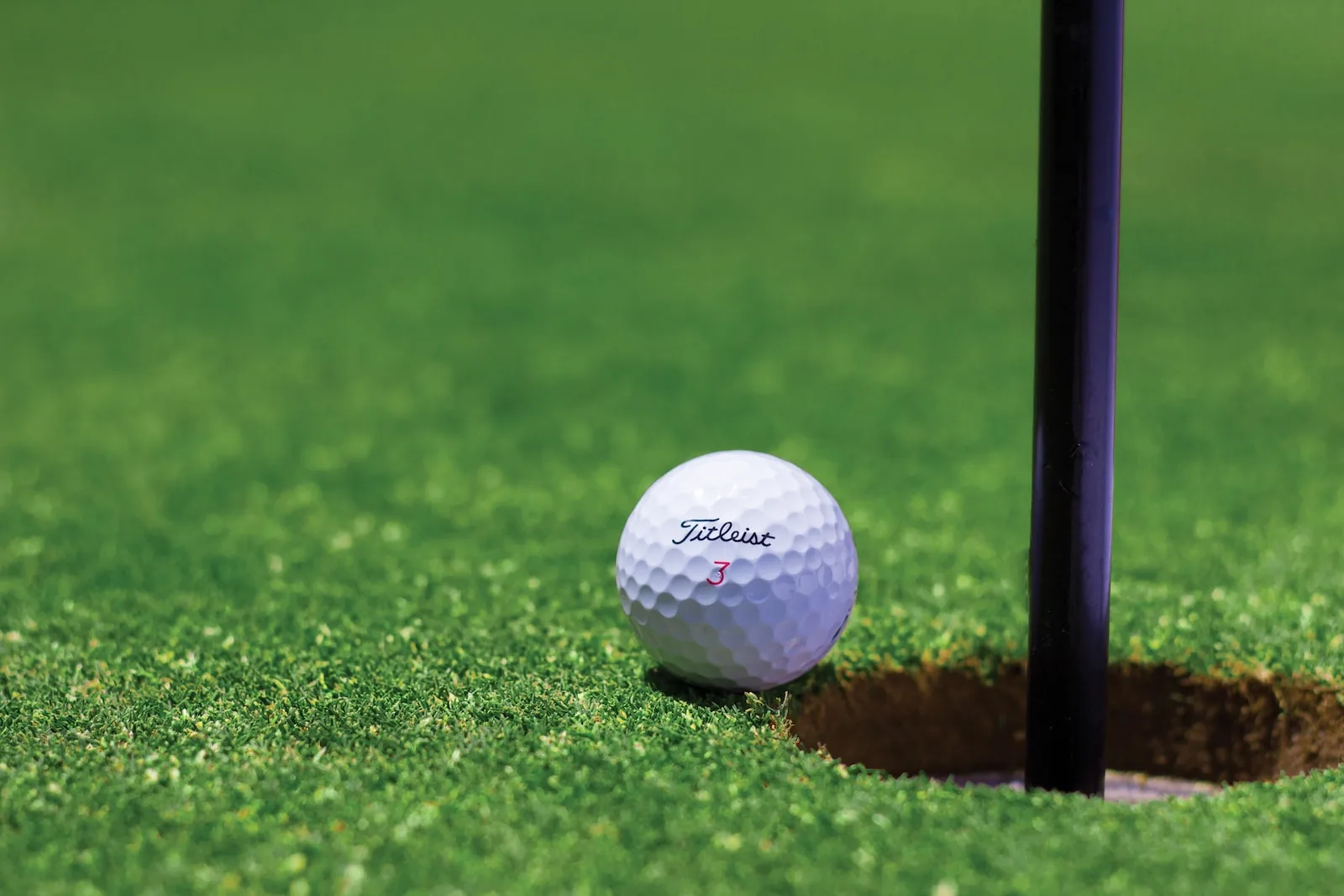 Pallina da golf accanto alla buca sul green