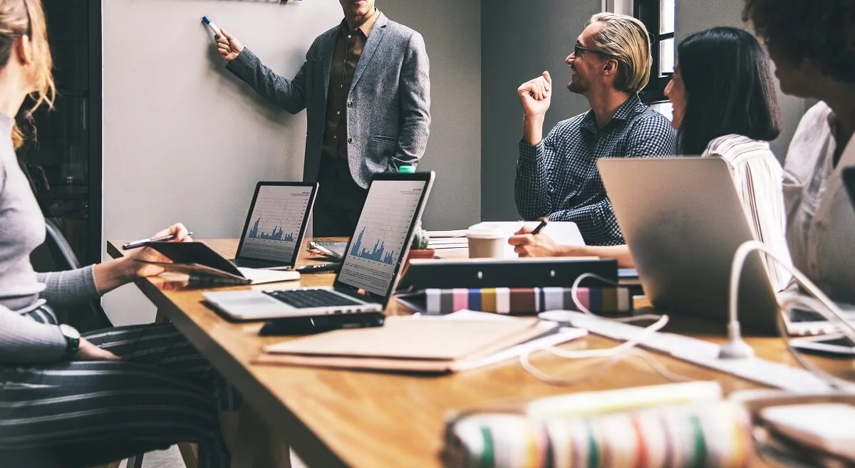 Riunione di lavoro attorno a un tavolo con computer portatili