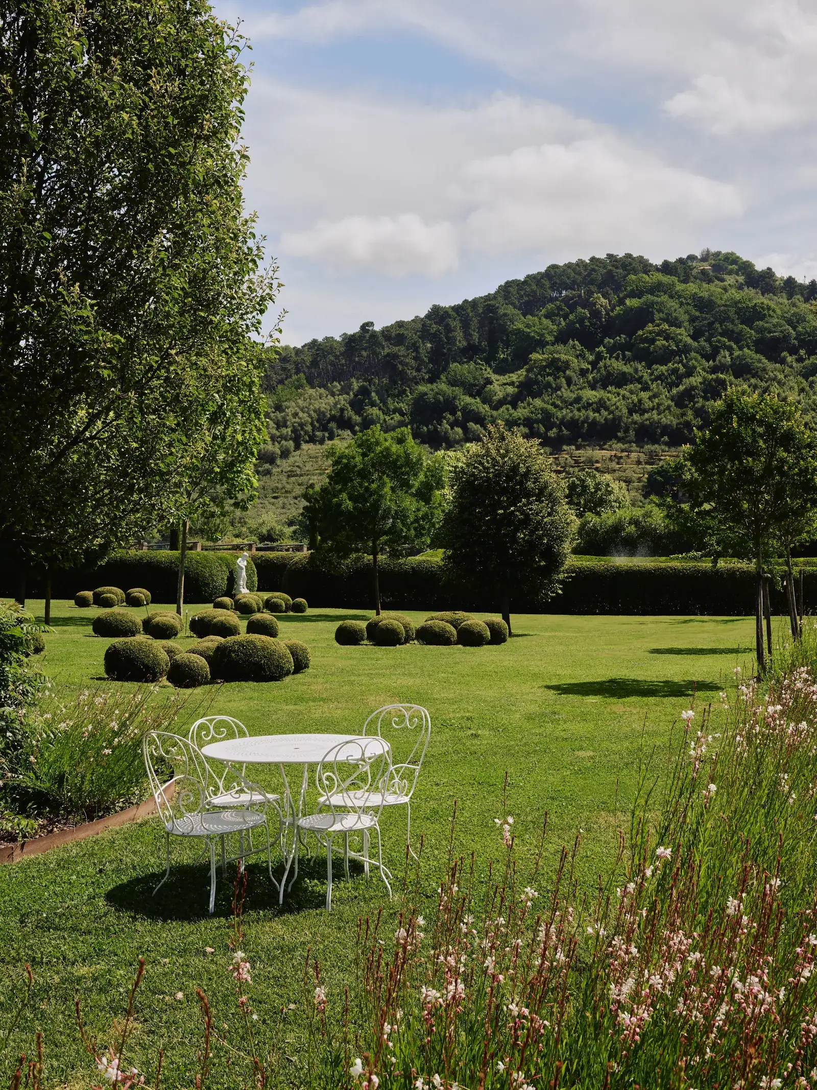 Tavolo e sedie bianche sul prato dei giardini di Villa Marie