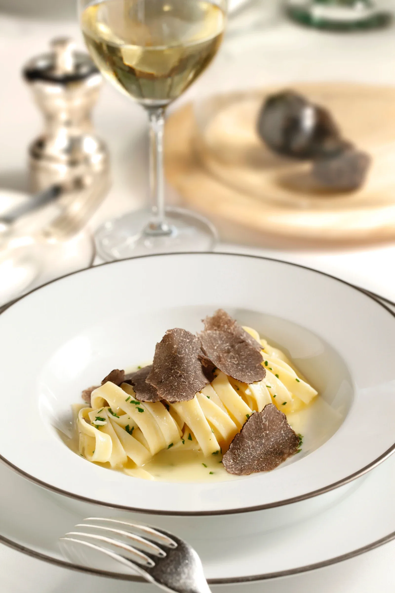 Fresh truffle pasta served with a glass of white wine